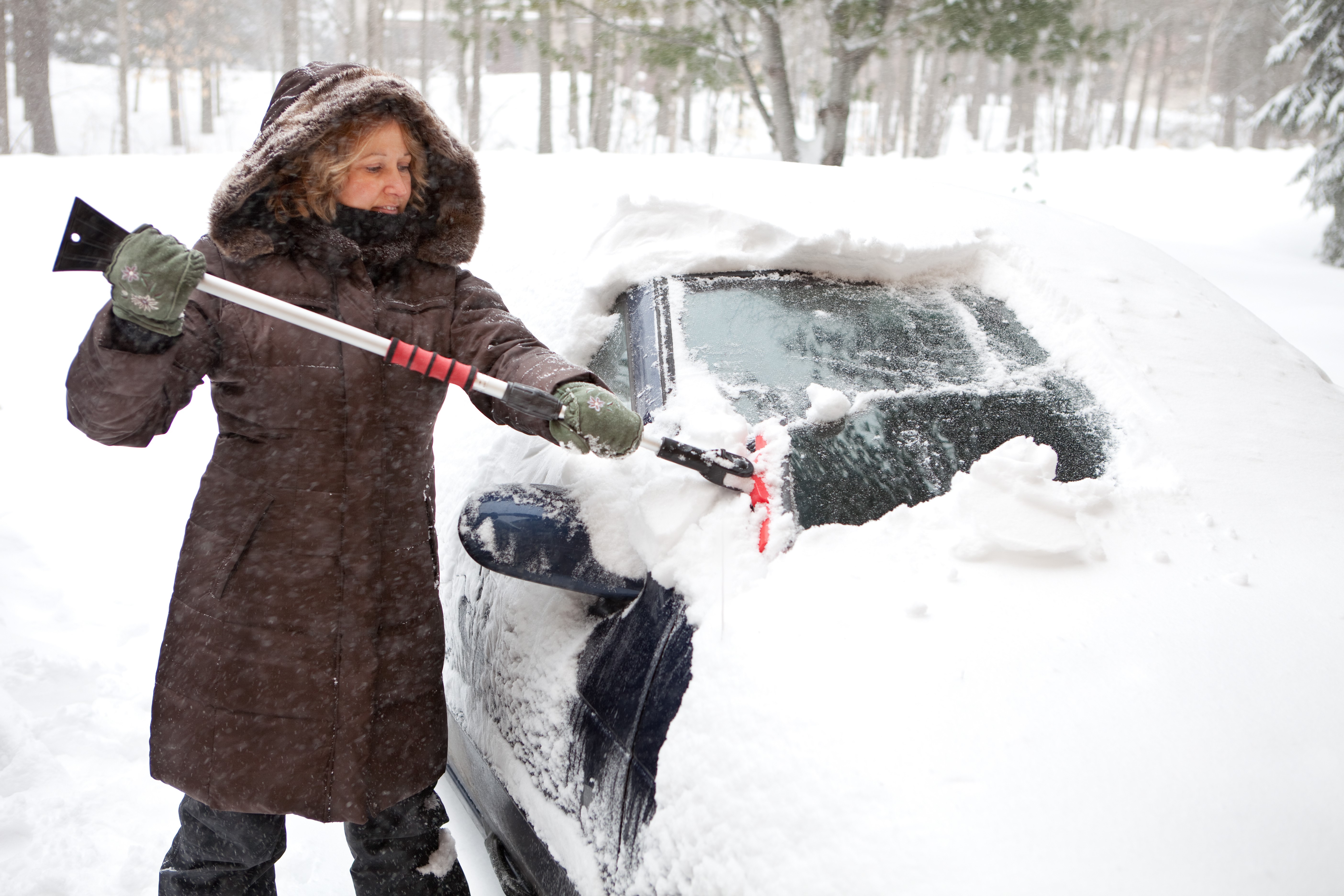 Woman Using an Ice Scraper on Her Car Windows